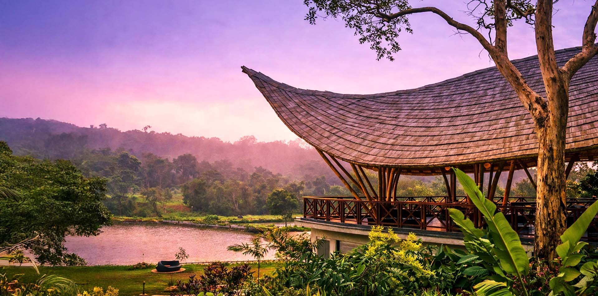 A curved pavilion roof over a misty lake at sunset, Coorg